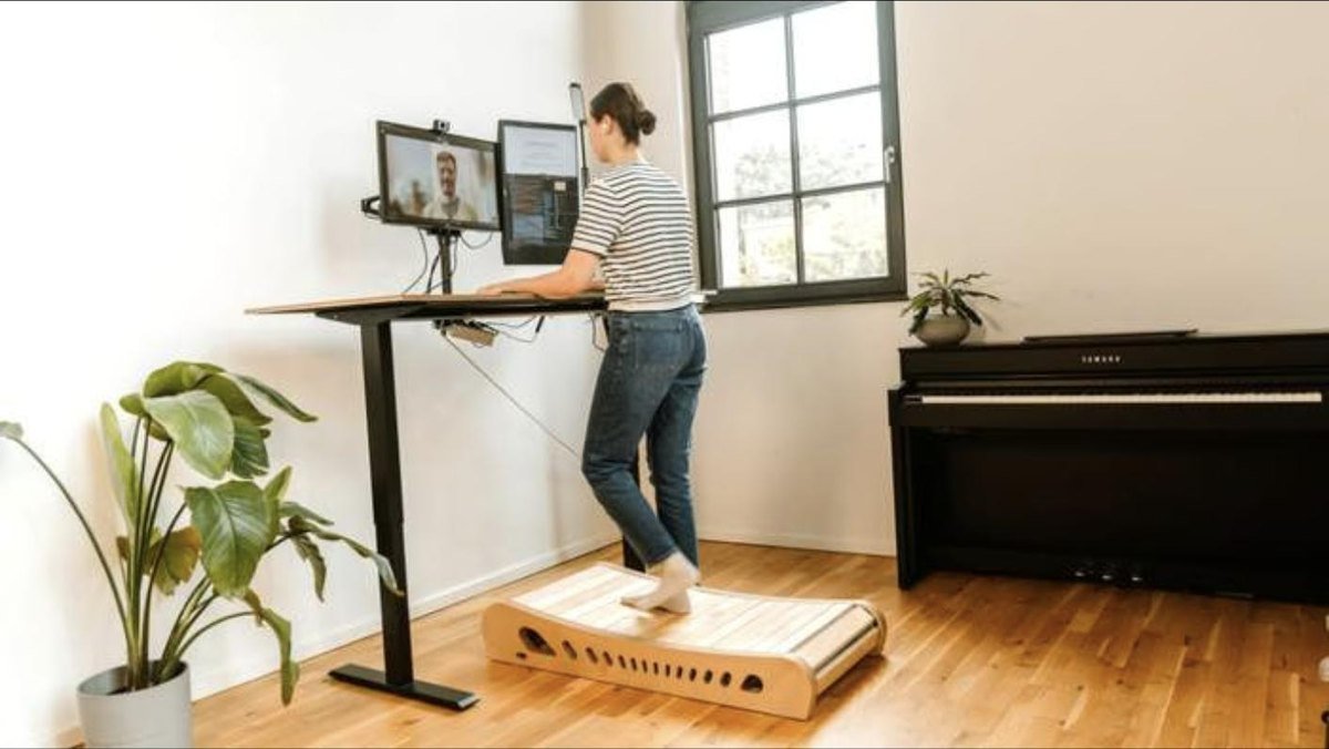 Someone walking on Woodway at a standing desk during a video call
